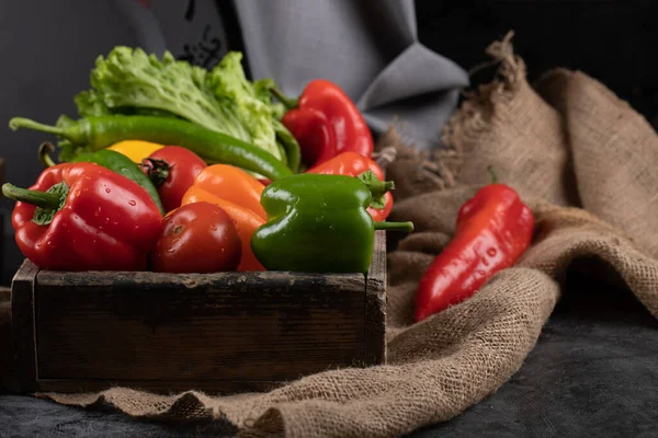 Färg paprika och grönska i en rustik bricka. — Stockfoto