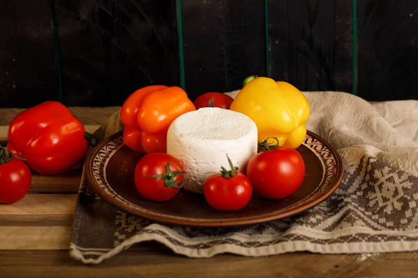 Hnědý talíř s bílým sýrem, rajčaty a paprikou uvnitř — Stock fotografie
