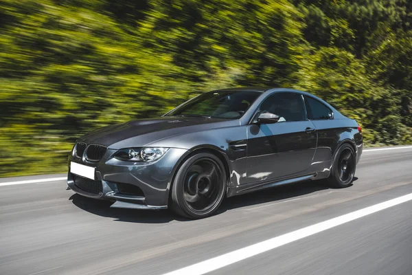 Orman yolunda yeşil birinci sınıf sedan.