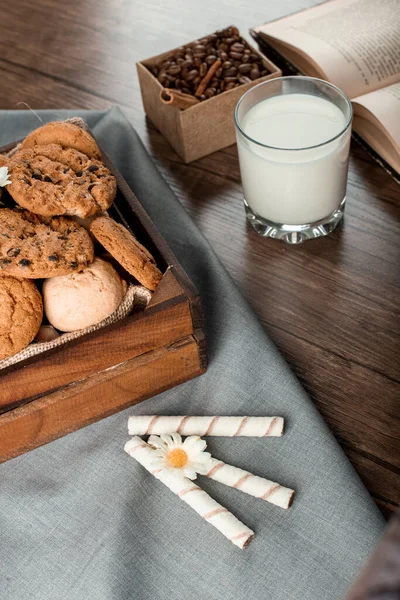 Bandeja de biscoitos e um copo de leite em uma mesa de madeira — Fotografia de Stock