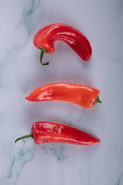 Üç kırmızı biber mavi bir mermer üzerinde