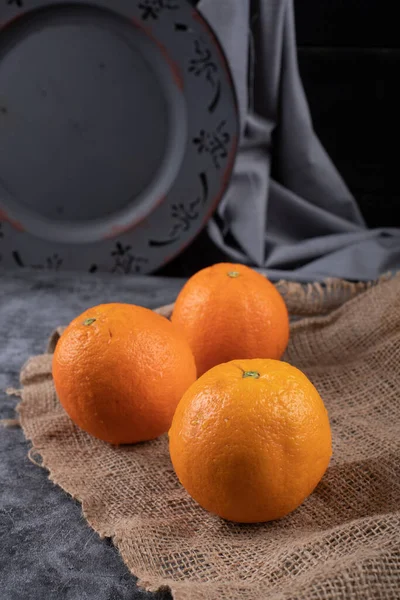 Naranjas frescas con un plato oscuro detrás . — Foto de Stock