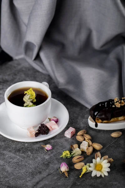 Чашка чая с турецким локумом, фисташками и шоколадным пирогом — стоковое фото