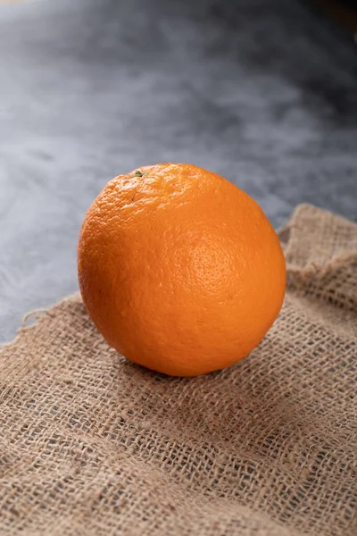 Una naranja sobre un fondo azul . — Foto de Stock