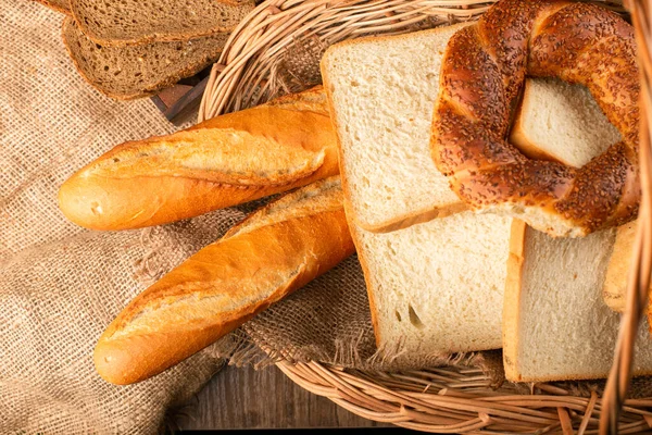 Baguete francesa com fatias de pão e bagels em cesta — Fotografia de Stock