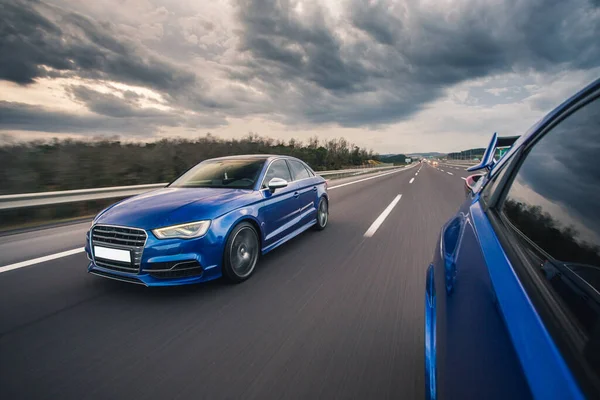 Blue sport cars racing on the highway — Stock Photo, Image