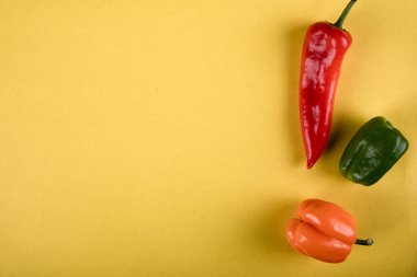 Sarı arka planda üç renkli kırmızı biber
