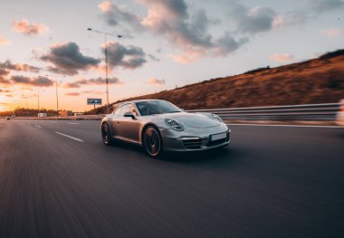 Gümüş renkli spor bir süvari tepeleri aşıyor.