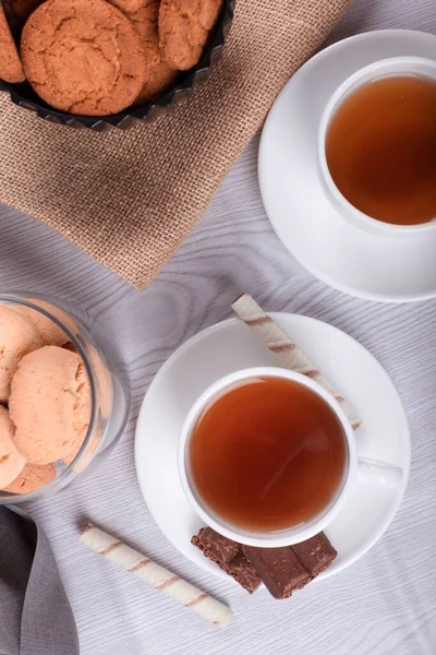 Sweet snacks, cup of tea on light background — Stock Photo, Image
