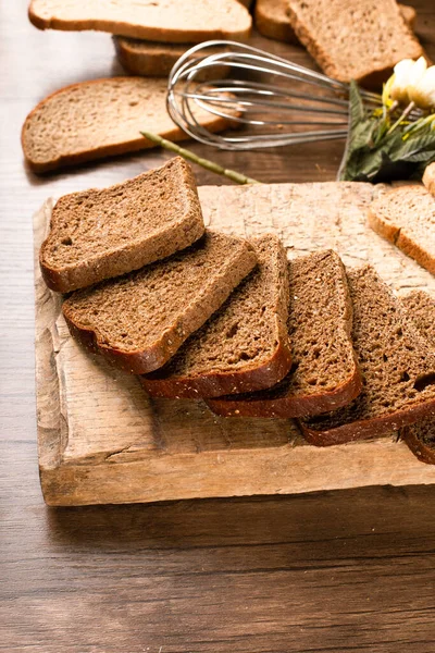 Slices of dark bread on the kitchen board — Stock Photo, Image
