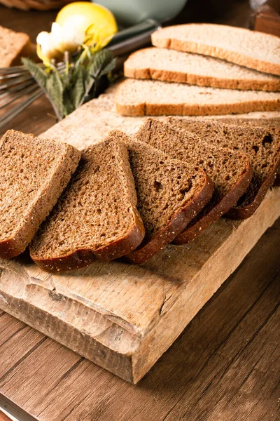 Slices of dark bread on the kitchen board — Stock Photo, Image