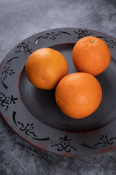 Naranjas frescas en un plato decorativo azul. Vista superior . — Foto de Stock