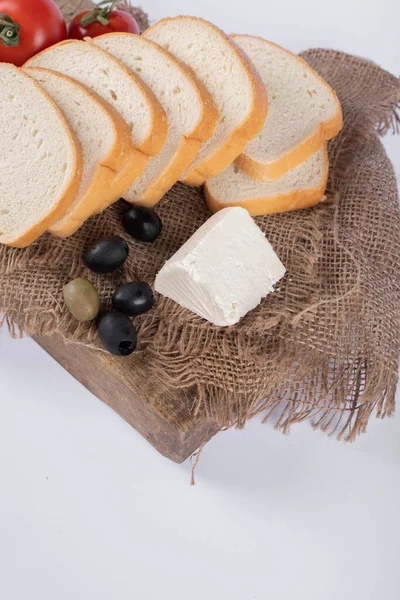 Weißbrot in Scheiben geschnitten und mit Oliven und Käse serviert — Stockfoto