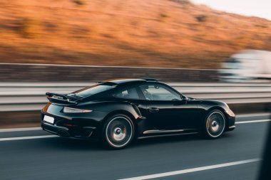 Siyah spor sedan yüksek hız sürücüsü otobanda tarlalarda