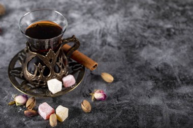 Bir bardak çay, şam fıstığı, Türk Lokum 'u ve tarçın mavi bir mermerde.
