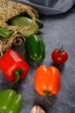 Taş bir masada dolmalık biber ve domates.