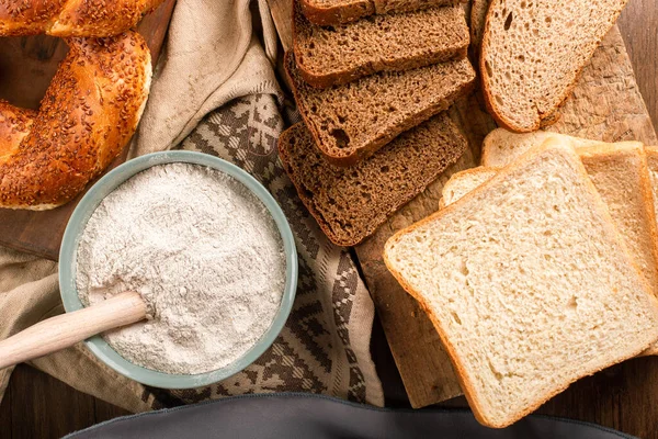 Bagels com fatias de pão e tigela de farinha — Fotografia de Stock
