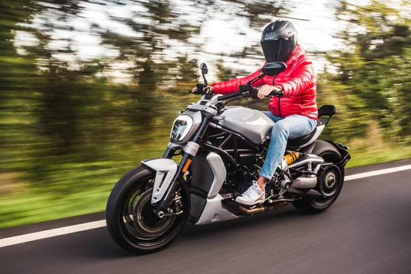 Biker in red gear driving a motorcycle in the forest — Stock Photo, Image