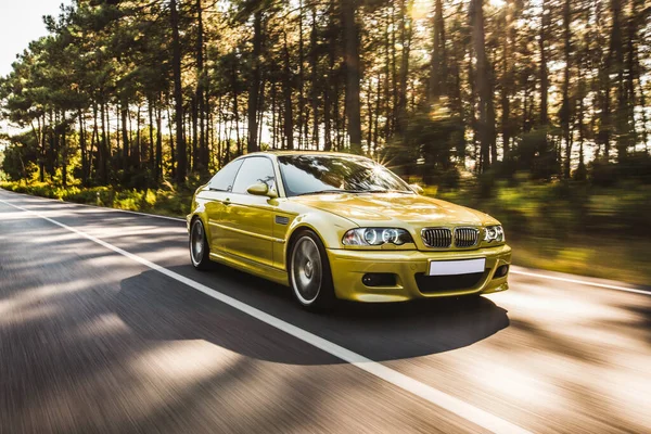 Sarı eski model sedan yolda.