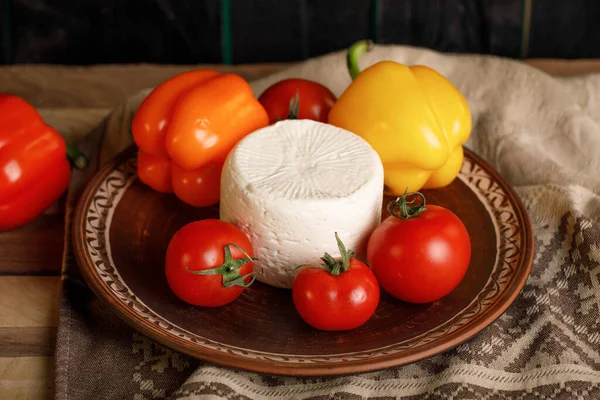 Placa de queso con tomate y pimientos sobre un fondo rústico —  Fotos de Stock