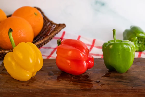 Pimentos de sino tricolor em uma placa de corte — Fotografia de Stock