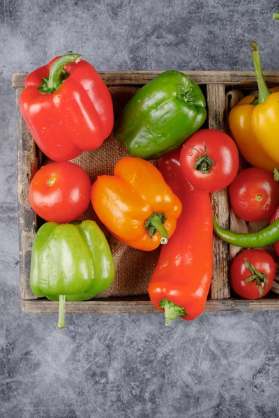 Säsongsfärgad paprika i en rustik bricka. Ovanifrån. — Stockfoto