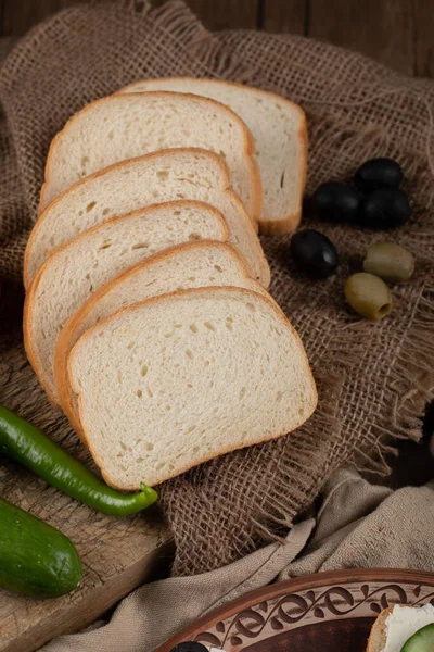 Finely sliced white bread in rustic background. — Stock Photo, Image