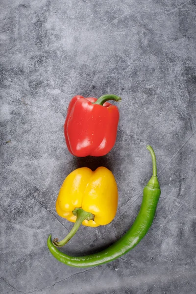 Művészi fotózás vörös, sárga paprikáról és zöld chiliről. Felülnézet. — Stock Fotó