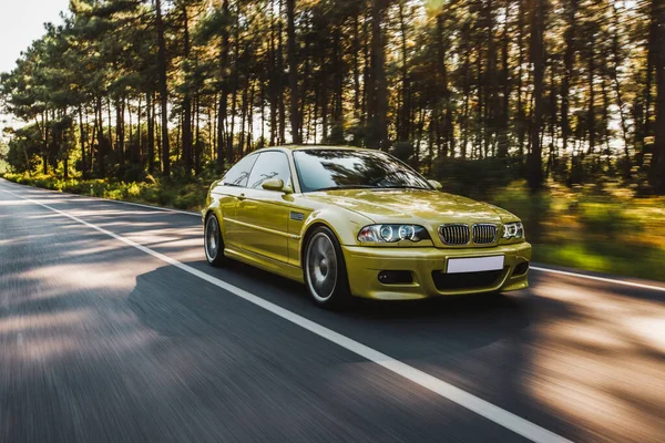 Sedan model galben vechi de conducere pe drumul forestier. vedere frontală — Fotografie, imagine de stoc