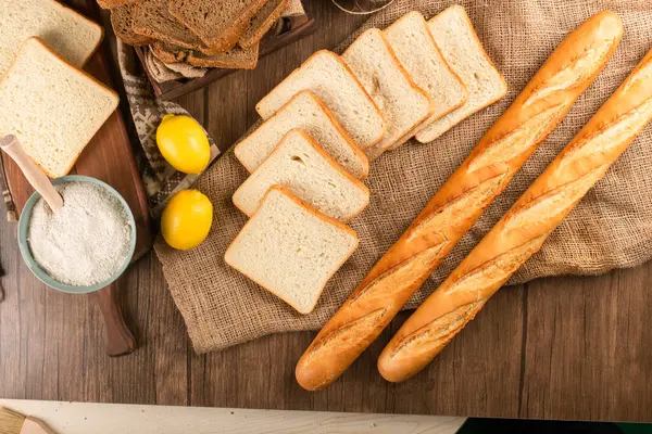 Baguete francesa com fatias de pão na cesta — Fotografia de Stock