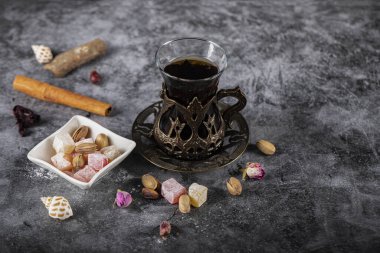 Fıstıklı Türk lokum, tarçınlı çubuk ve bir bardak çay.