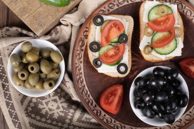 Tabakta mini sandviçle marine edilmiş siyah zeytin. Üst görünüm