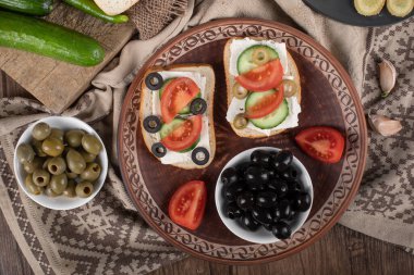 Kahverengi tabakta marine edilmiş yeşil zeytinli mini sandviçler