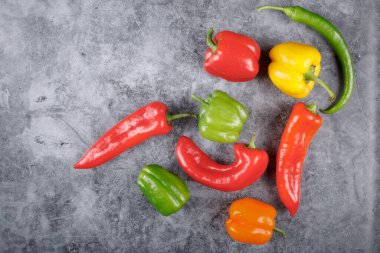 Mavi taşın üzerinde tatlı dolmalık biber ve biber var. Üst görünüm.