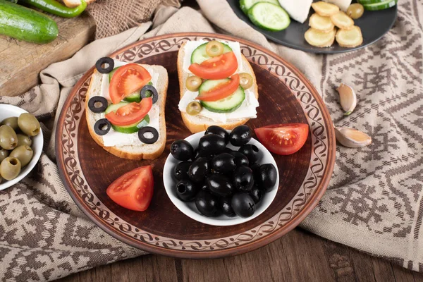 Black marinated olives with mini sandwiches in a platter. — Stock Photo, Image