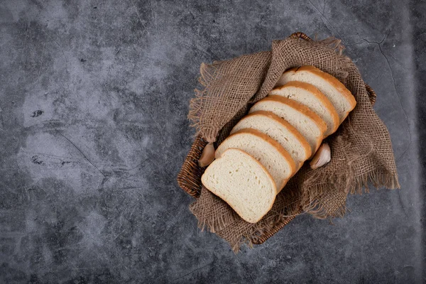 Thin sliced white bread on a piece of burlap. — Stock Photo, Image