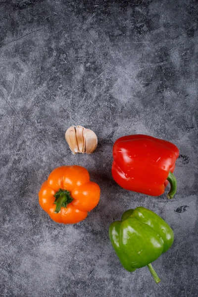 Barevné papriky a česnek na modrém pozadí. — Stock fotografie