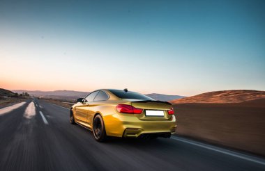 Otobanda kırmızı ksenon ışıkları olan sarı spor araba.