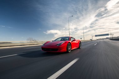 Kırmızı ışıklı kırmızı lüks spor araba, önden manzara