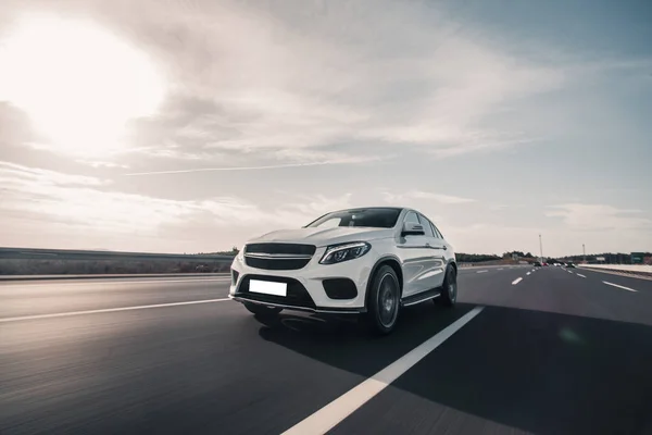 Witte sport model auto hoge snelheid rijden op de snelweg onder de volle zon — Stockfoto