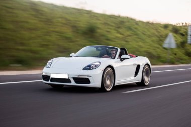 Highlands 'da, otobanda giden beyaz süper model Cabriolet araba.