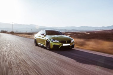 Otoyolda giden yeşil sedan araba. 