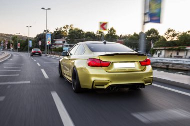 Şehir yollarında sarı sedan araba.