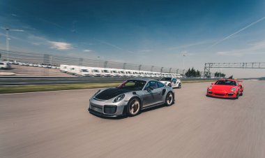 Kırmızı ve gümüş renkli spor arabalar pistte yarışıyor.