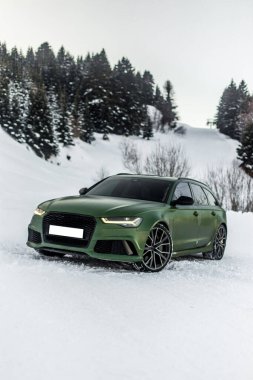 Yeşil spor model off roader meşe ağaçları arasında karlı bir ormanda