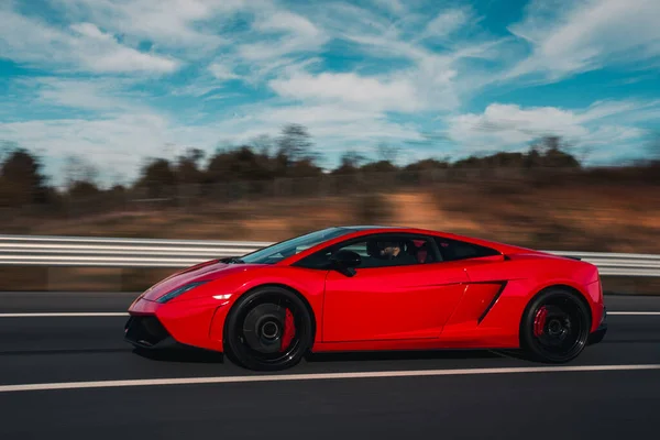 Red cabriolet driving under the blue sky — Stock Photo, Image