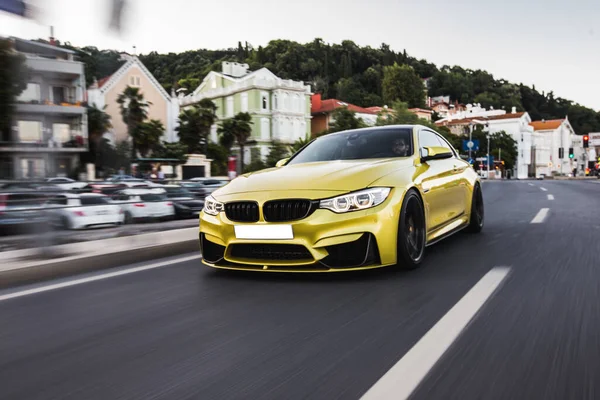 Condução de carro esporte amarelo na estrada da cidade no entardecer — Fotografia de Stock