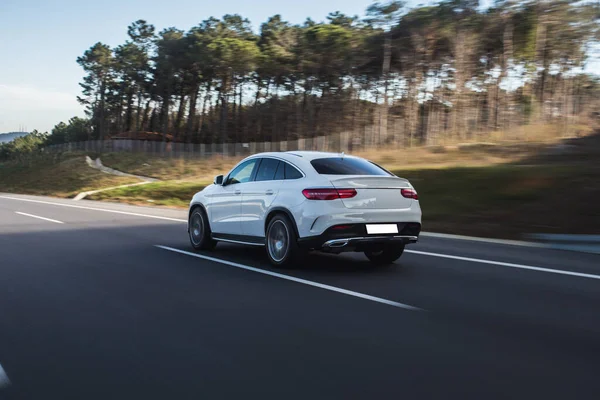 Blanco modelo deportivo coche de alta velocidad de conducción en la carretera a través de los bosques —  Fotos de Stock