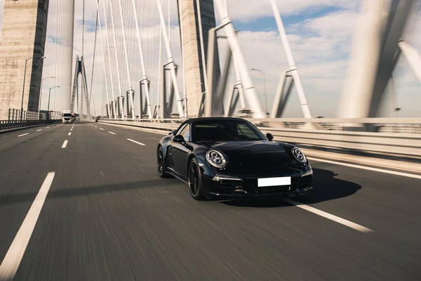 Cabriolet deportivo negro conduciendo por el puente — Foto de Stock