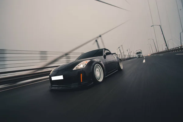 Schwarzer Sportwagen im Nebel auf der Autobahn — Stockfoto